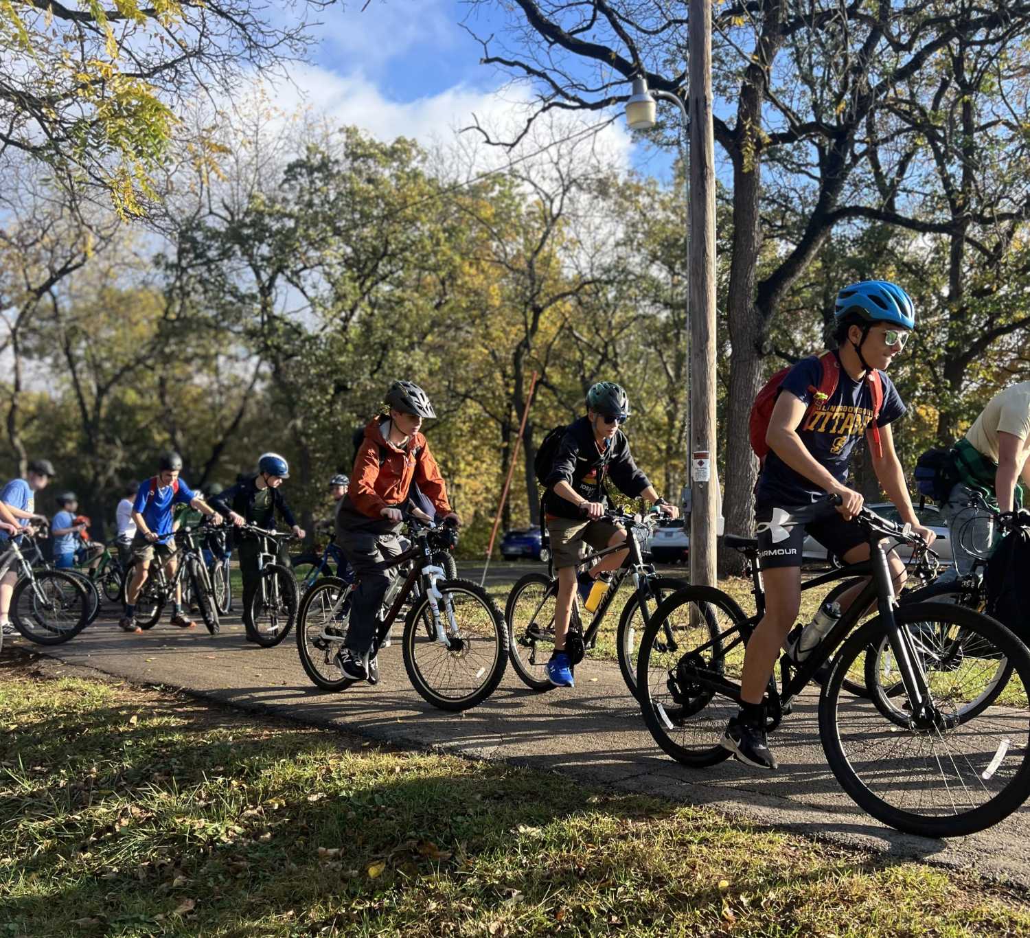 Scouts in mountain bikes ride on a paved trail