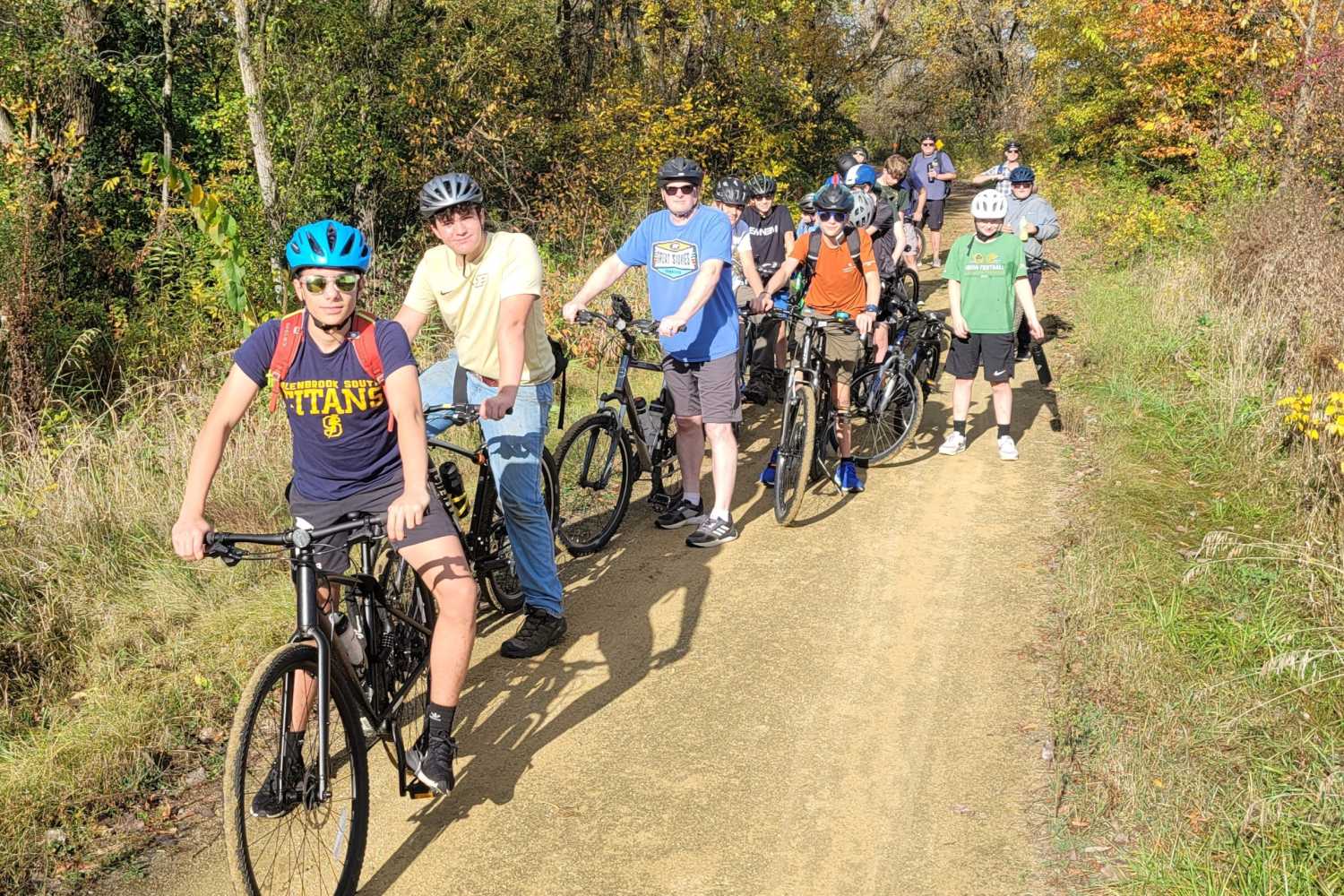 Scouts ride mountain bikes together on a dirt trail